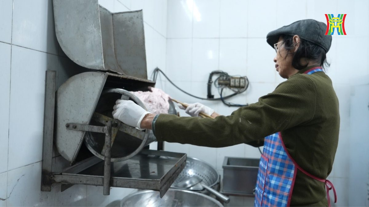 Bác Bình cho thịt vào máy xay giò